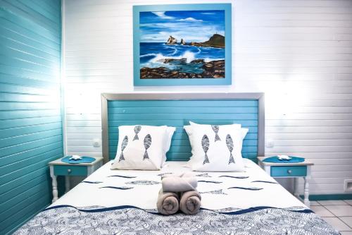 a bedroom with a bed with a blue head board at Résidence Paradis Tropical in Basse-Terre