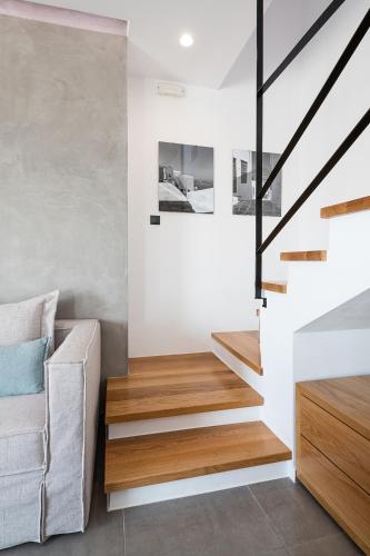 a staircase in a living room with wood and white walls at PhantΩm Villas Villa Hero in Kókkinon Khoríon
