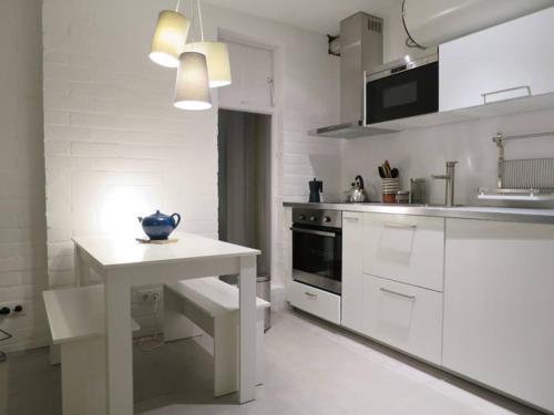 a white kitchen with a table and a white counter top at come and enjoy ! in Cadaqués