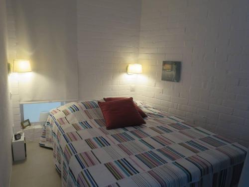 a bedroom with a bed with a red pillow on it at come and enjoy ! in Cadaqués