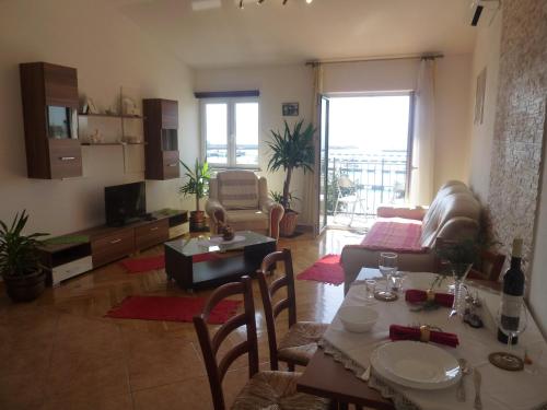 sala de estar con mesa y sofá en Apartments Monika, en Novi Vinodolski