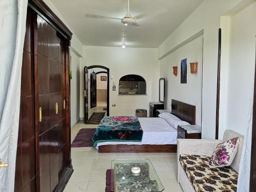 a bedroom with a bed and a couch in a room at Luxor hotel Bella Vista Apartments and Hotel in Luxor