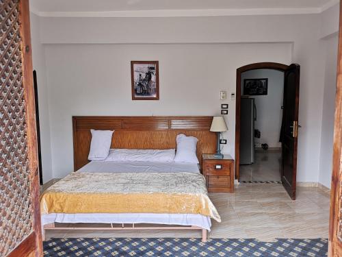 a bedroom with a large bed with a wooden headboard at Luxor hotel Bella Vista Apartments and Hotel in Luxor