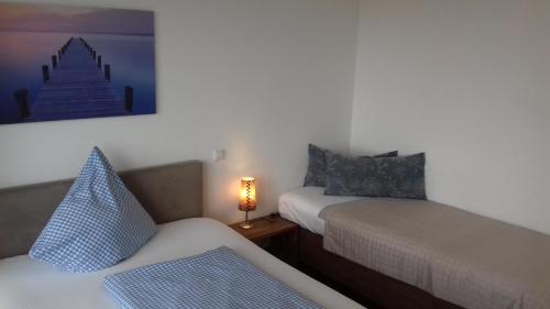 Zimmer mit 2 Betten und einer Lampe auf einem Tisch in der Unterkunft Ammergauer Vier Jahreszeiten in Bad Kohlgrub