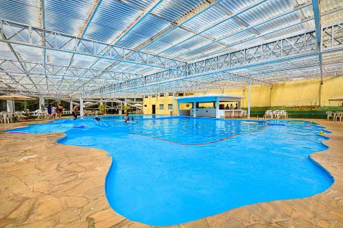 uma grande piscina interior com água azul em Hotel Cabeça de Boi em Monte Verde