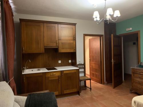 uma cozinha com um lavatório e armários de madeira em Molino Grande del Duratón em San Miguel de Bernúy
