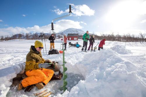 a person sitting in a pile of snow at Lapphaugen Turiststasjon in Tennevoll