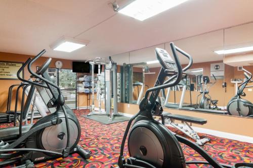 a gym with several exercise bikes and mirrors at LeBossier Hotel in Bossier City