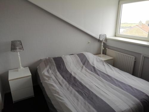 a bedroom with a bed and a window at Princestraat in Katwijk aan Zee