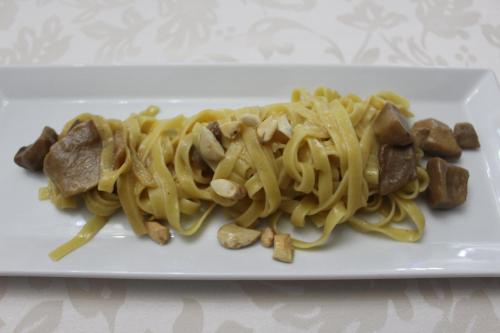 a white plate of pasta with meat and noodles at Hotel Lo Scoiattolo in Cotronei