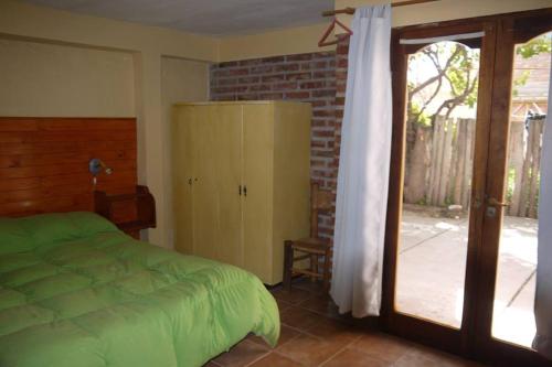 una camera da letto con un letto e una porta scorrevole in vetro di SOL PATAGONICO a Playas Doradas