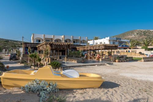 a yellow boat on the sand in front of a resort at Zanetos Prasonisi in Prasonisi