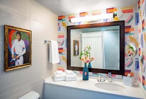 uma casa de banho com um lavatório e um espelho em Graduate Fayetteville em Fayetteville