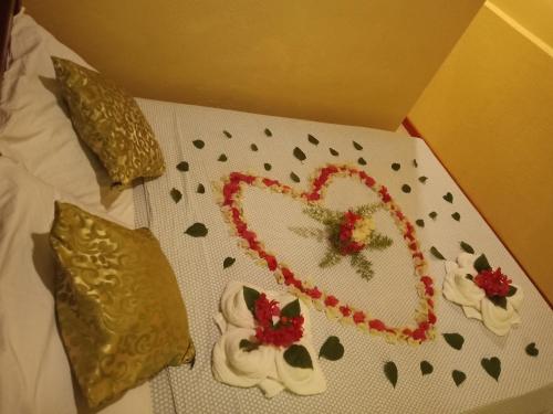 a box with a heart and flowers on a bed at TAGBALAYON Lodging House in Siquijor