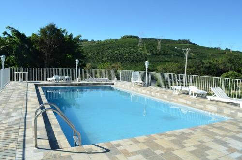 a large swimming pool with a metal fence at Pousada Primavera da Serra in Serra Negra