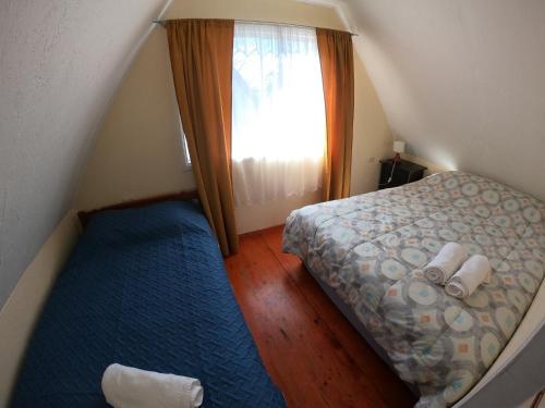 Habitación pequeña con cama y ventana en Cabañas Rio Leufucade, en Valdivia