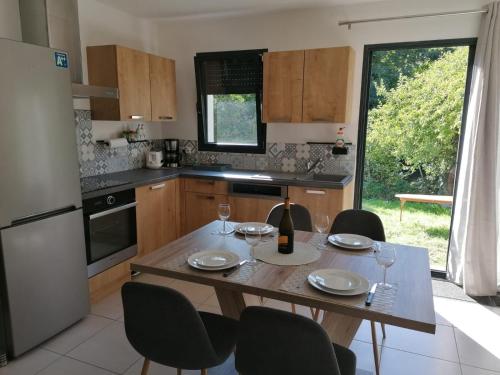 una cocina con mesa con sillas y una botella de vino en Ax Sweet Mountain - 3ch et 2 sdb - jardin centre village, en Ax-les-Thermes