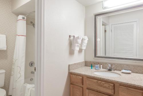 a bathroom with a sink and a mirror at Craigshire Suites St Louis Westport Plaza in Maryland Heights