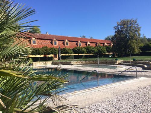 a swimming pool with a house in the background at Dvůr Pecínov in Benešov