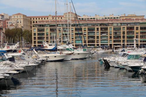 een groep boten aangemeerd in een haven met gebouwen bij Escapade Vieux-Port in Marseille
