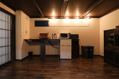 a room with a kitchen with a microwave and a refrigerator at Yurakuan - Awagami Residence Inn in Kyoto