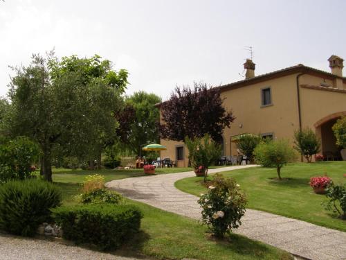 a garden with a house and a walkway at Agriturismo Verbena in Castiglione del Lago