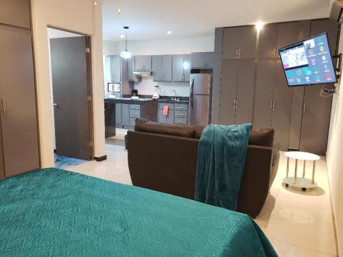 sala de estar con sofá y cocina en Privatto Suites en Saltillo