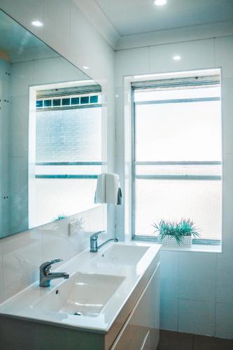a bathroom with two sinks and a large mirror at Summer House Kings Cross in Sydney