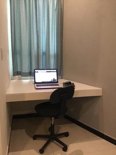a laptop computer sitting on a desk with a window at Privatto Suites in Saltillo