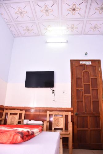 a room with two beds and a flat screen tv at Thanh Thúy Guesthouse in Ðông Hà
