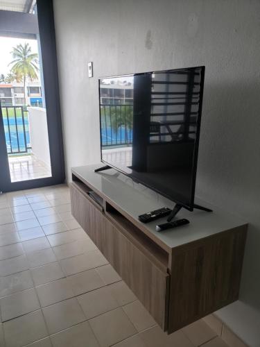 a flat screen tv sitting on top of a counter at Relax Beachfront Complex at Rio Grande in Rio Grande