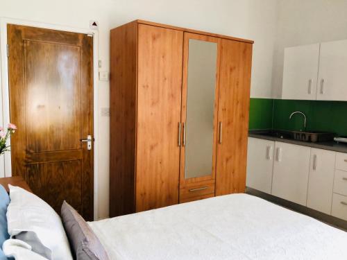 a bedroom with a bed and a wooden cabinet at Sacha Tourist Residence 2 in Mahébourg