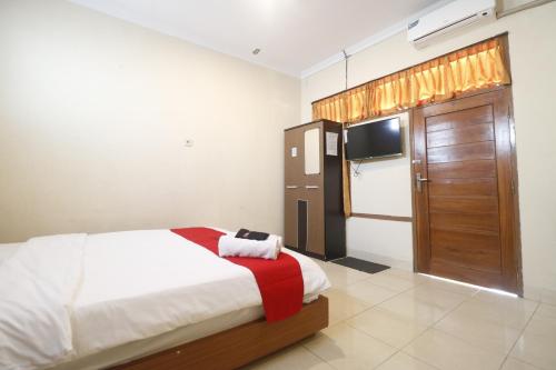 a bedroom with a bed and a television in it at RedDoorz Plus @ Jalan Parangtritis 2 in Yogyakarta