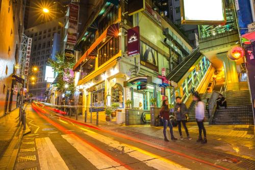 a group of people walking down a city street at night at Butterfly on Wellington, Central in Hong Kong