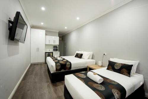 a hotel room with two beds and a tv at City Centre Motel Hotel in Port Pirie