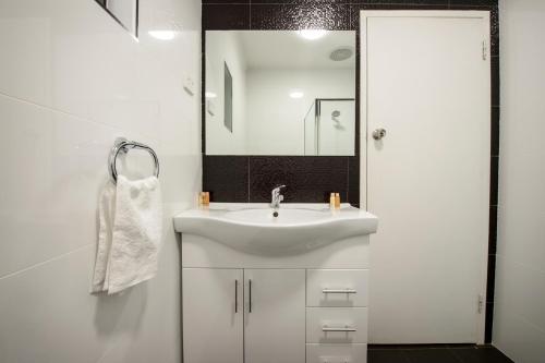 a white bathroom with a sink and a mirror at City Centre Motel Hotel in Port Pirie