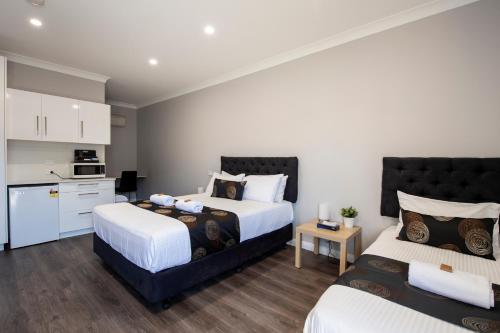 a bedroom with two beds and a kitchen at City Centre Motel Hotel in Port Pirie