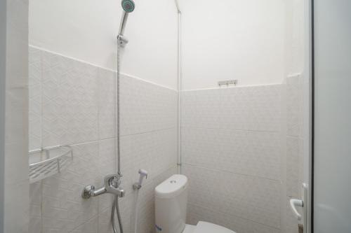 La salle de bains est pourvue d'une douche et de toilettes. dans l'établissement RedDoorz Plus at Grand Tara Homestay Palembang, à Palembang