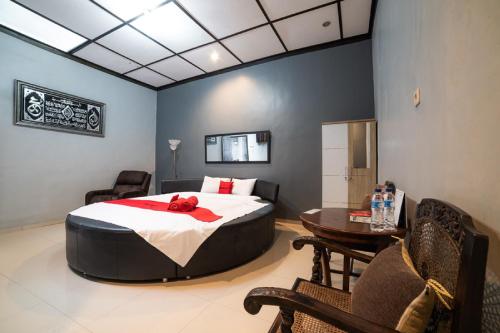 a bedroom with a bed and a table and chairs at RedDoorz Syariah near RRI Malang in Malang