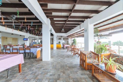 ein leeres Restaurant mit Tischen, Stühlen und Tisch in der Unterkunft RedDoorz Plus at Hotel Metro Kalibo in Kalibo