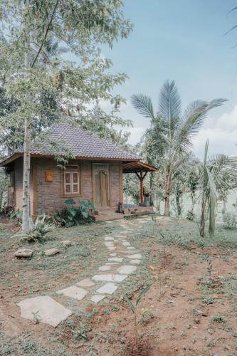 a small house with a stone path in front of it at Saridevi Ecolodge in Jatiluwih