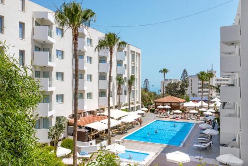 an aerial view of a hotel with a swimming pool and palm trees at Alva Hotel Apartments in Protaras