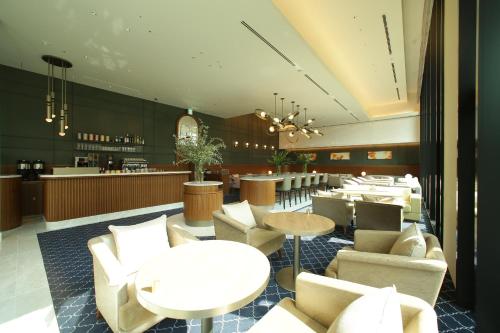 a restaurant with white tables and chairs and a bar at Miyako Hotel Hakata in Fukuoka