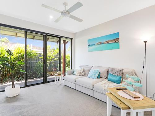 a living room with a white couch and a table at WATERFRONT HOME BORDERING MOOLOOLABA in Buddina