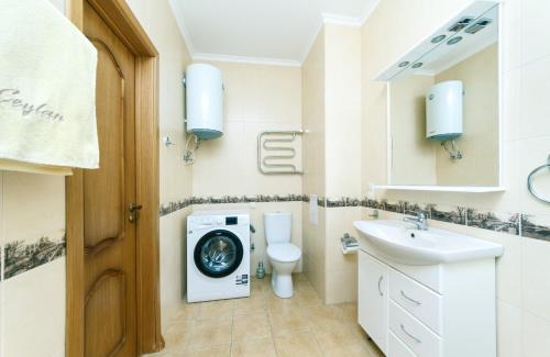 ein Badezimmer mit einer Waschmaschine und einem Waschbecken in der Unterkunft Прекрасная однокомнатная квартира с чудесным видом из окна in Kiew