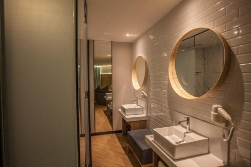 a bathroom with two sinks and a mirror at HAKO HOTEL (MOUNT AUSTIN) in Johor Bahru