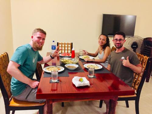 a group of people sitting around a table eating food at Sweet Home Tourist Rest, Cooking Classes & Tours in Anuradhapura