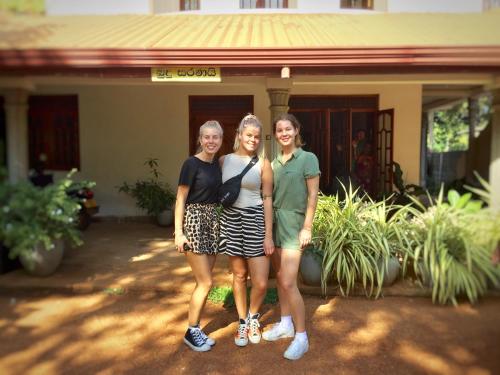 three women are standing in front of a house at Sweet Home Tourist Rest, Cooking Classes & Tours in Anuradhapura