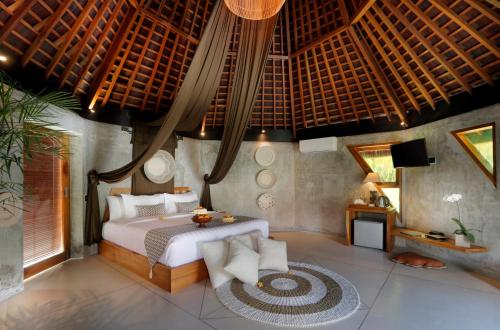 um quarto com uma cama grande num quarto em The Sender Pool Suites em Ubud