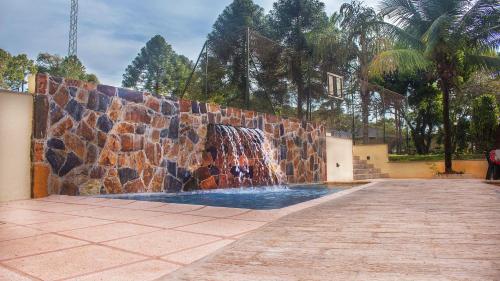 uma parede de pedra com uma fonte de água em Pirayu Lodge Resort em Porto Iguaçu